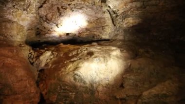 Fenerli turistler kayadaki Doğal Mağara boyunca yürürler. Kayadaki doğal mağara. Yeraltında, aydınlık taş ve dikitlerle dolu bir mağara.. 