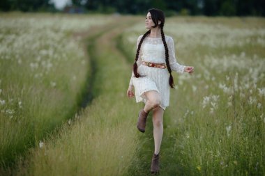 Sevinçle yaz alanında çalışan uzun siyah saçlı genç kız.