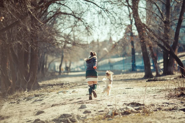 Girl playing with her dog in the park. — Stock Photo, Image