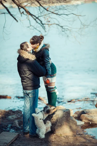 Man and woman playing with their dog at the river. — Stock Photo, Image