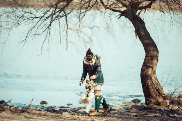 Dívka si hraje se svým psem na pobřeží řeky. — Stock fotografie