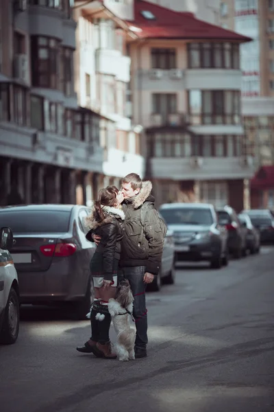 Mann und Frau spazieren mit Hund auf der Straße. — Stockfoto