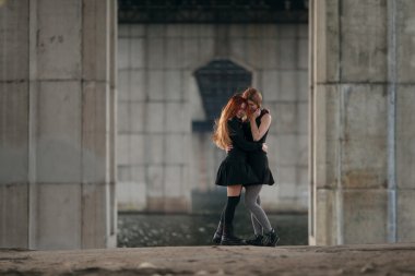 İki kızla birlikte kentsel köprü altında sarılma.