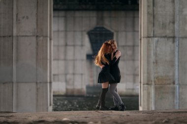 İki kızla birlikte kentsel köprü altında sarılma.