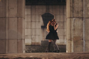 İki kızla birlikte kentsel köprü altında sarılma.