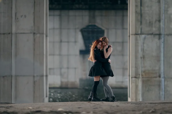都市の橋の下で一緒に抱いて二人の女の子. — ストック写真