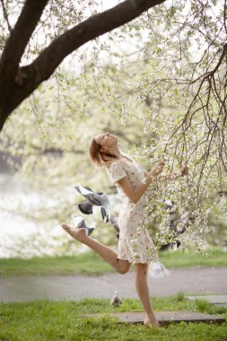Bahar bahçe güvercinlerin ile dans güzel kız.