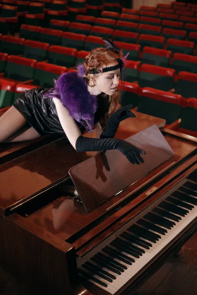 극장에 있는 피아노에 누워 빈티지 드레스에 아름 다운 여자. — 스톡 사진