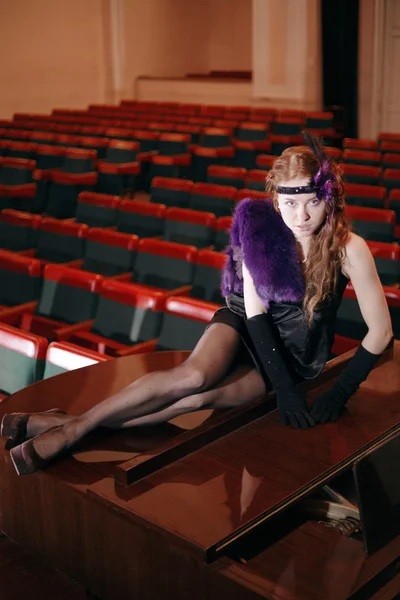 Bella ragazza in abito vintage sdraiata sul pianoforte in teatro . — Foto Stock