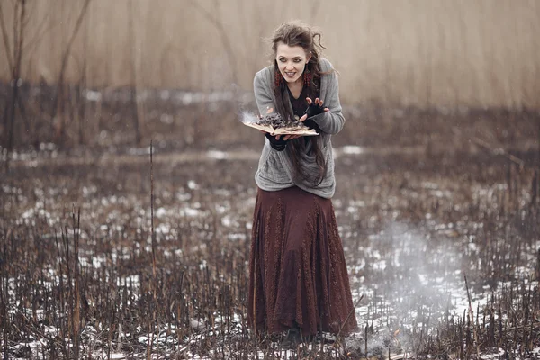 Bruja malvada lanzando hechizos mágicos en el campo quemado . — Foto de Stock