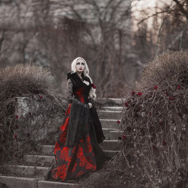 Beautiful woman with long blonde hair in old fashioned red dress — Stock Photo, Image