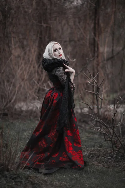 Vacker kvinna med långa blonda hår i gamla gammaldags röd klänning — Stockfoto