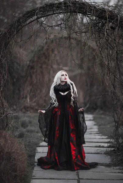 Красивая женщина с длинными светлыми волосами в старомодном красном платье — стоковое фото