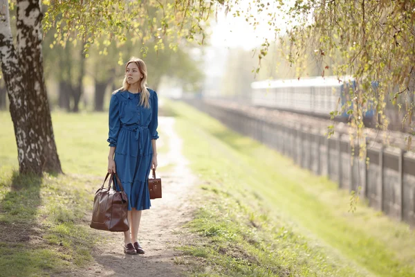 Jonge reiziger in vintage blauwe jurk laat home voor avonturen. — Stockfoto