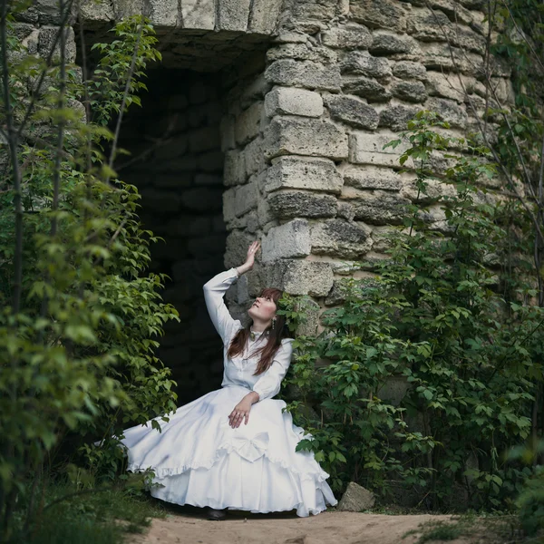 Menina bonita em vestido vintage branco andando perto de casa de pedra antiga. Conceito nupcial vintage — Fotografia de Stock