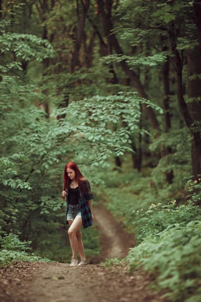 Chica pelirroja joven caminando por el bosque verde fresco. Concepto turístico . —  Fotos de Stock