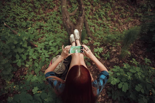 Девушка фотографирует ноги в лесу. Концепция гаджета. Концепция путешествия . — стоковое фото