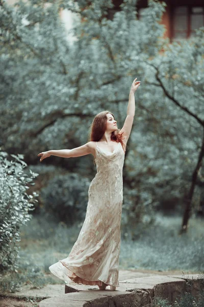 Young girl in beautiful dress and pointe shoes dancing on the street. — Stock Photo, Image