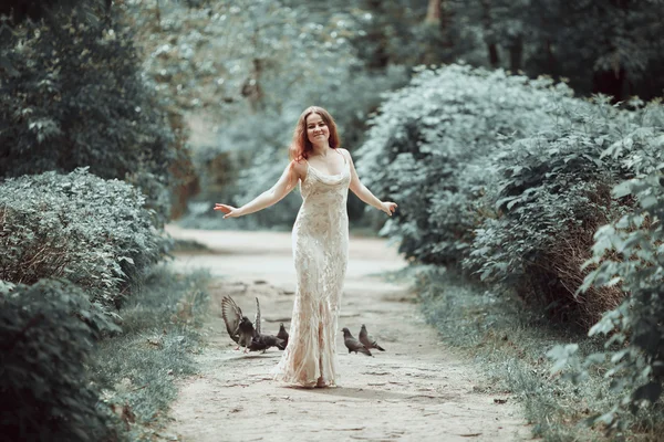 Genç kız güzel elbise ve pointe ayakkabı uçan güvercinler ile sokakta dans. — Stok fotoğraf