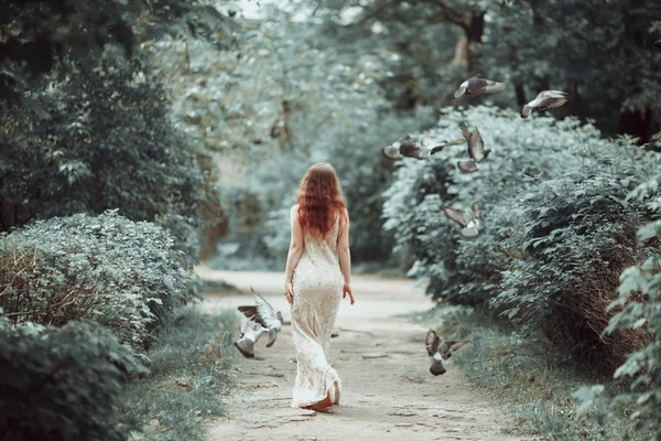 Jeune fille en belle robe et chaussures pointes dansant dans la rue avec des pigeons volants . — Photo