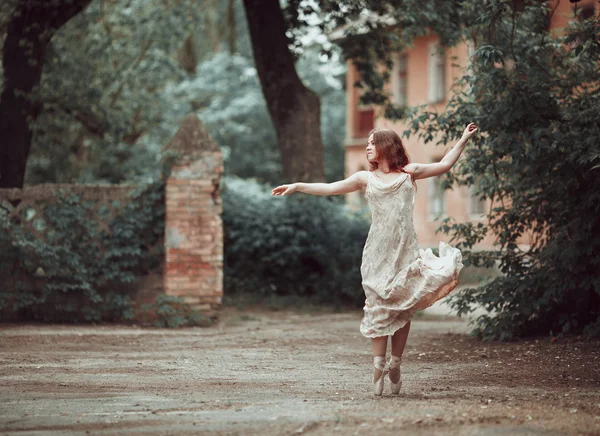 Jeune fille en belle robe et pointes chaussures dansant dans la rue . — Photo