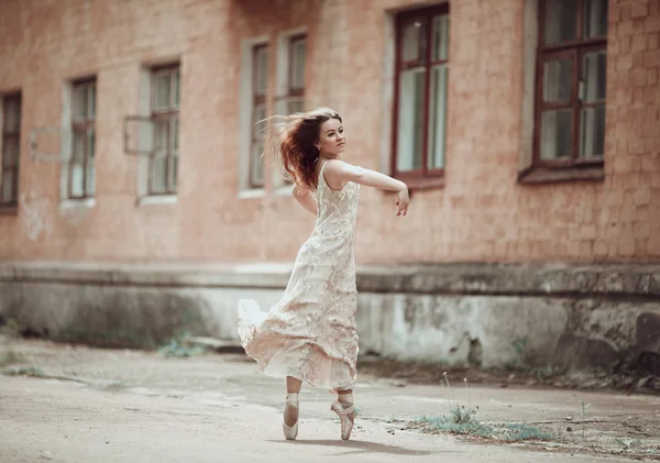 Young girl in beautiful dress and pointe shoes dancing on the st — Stock Photo, Image