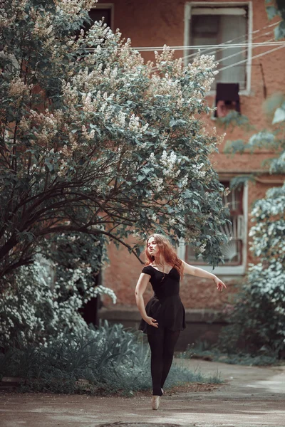 Jeune fille en belle robe et pointes chaussures dansant dans la rue . — Photo