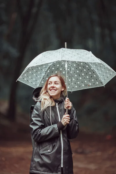 Junges Mädchen läuft mit Regenschirm durch einen Regenwald. — Stockfoto