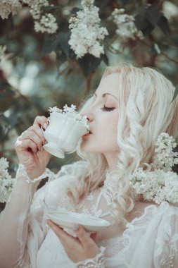 Çiçeklenme içinde güzel sarışın kadın leylak Bahçe. Vintage. Alice.