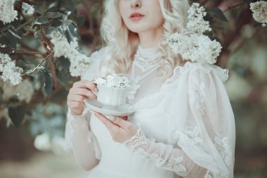 Çiçeklenme içinde güzel sarışın kadın leylak Bahçe. Vintage. Alice.