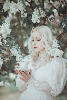 Çiçeklenme içinde güzel sarışın kadın leylak Bahçe. Vintage. Alice.