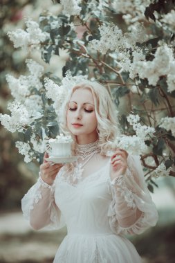 Çiçeklenme içinde güzel sarışın kadın leylak Bahçe. Vintage. Alice.