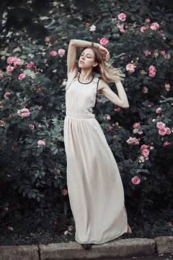 Güzel genç kız moda pembe elbise kokulu güller. Peri masalı. Moda. Fantezi