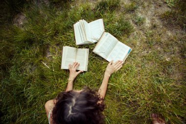 Yeşil çimenlerin üzerinde eğitim güzel genç kız. Kitap okuma