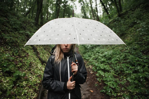 Giovane ragazza che cammina attraverso una foresta pluviale con ombrello . — Foto Stock
