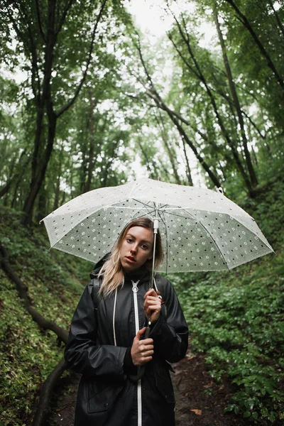 Jong meisje lopen door een regenachtige bos met paraplu. — Stockfoto