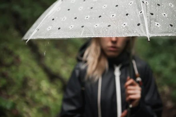 Молода дівчина йде через дощовий ліс з парасолькою . — стокове фото