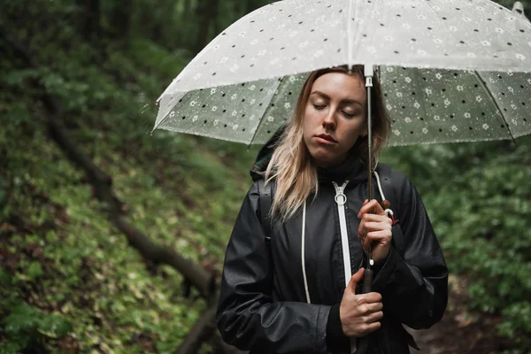 Jong meisje lopen door een regenachtige bos met paraplu. — Stockfoto