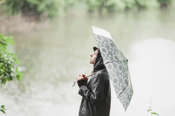 Junges Mädchen mit Regenschirm im Regen stehend. Raum für Text — Stockfoto