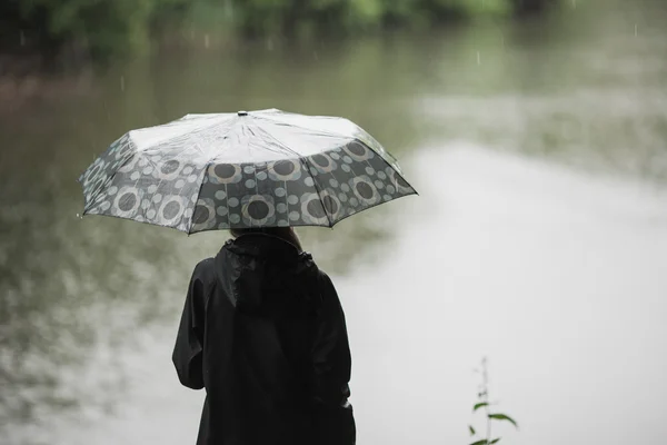 Junges Mädchen mit Regenschirm im Regen stehend. Raum für Text — Stockfoto