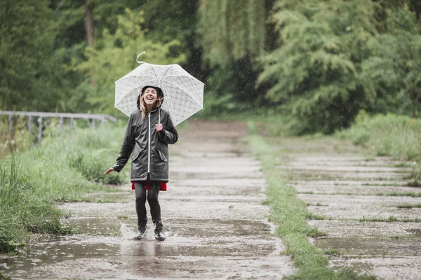 Menina se divertindo na chuva. Conceito de chuva alegre — Fotografia de Stock
