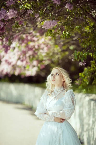 Belle femme blonde en fleurs jardin lilas. Concept de mariée vintage — Photo