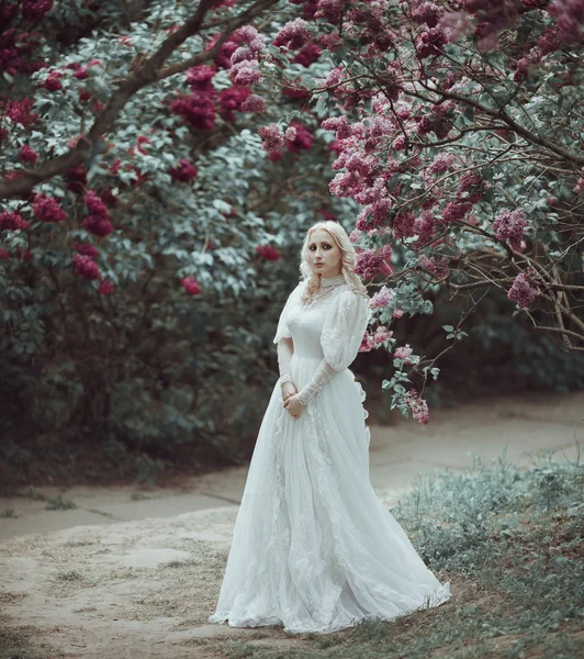 Bella donna bionda in fiore giardino lilla. Vintage sposa concetto — Foto Stock