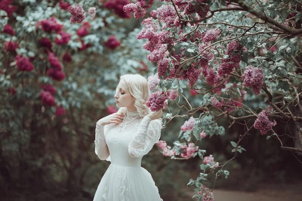 Bella donna bionda in fiore giardino lilla. Vintage sposa concetto — Foto Stock