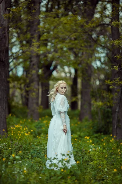 Beautiful blonde woman in blooming lilac garden. Vintage bride concept — Stock Photo, Image