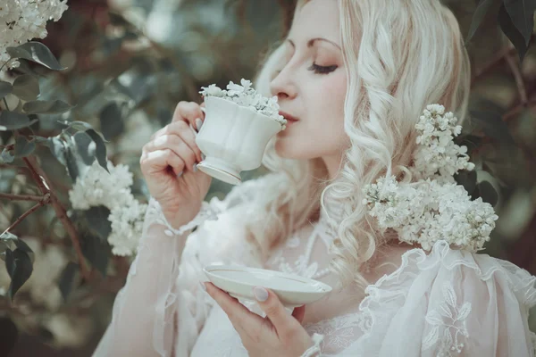 Beautiful blonde woman in blooming lilac garden. Vintage. Alice. — Stock Photo, Image