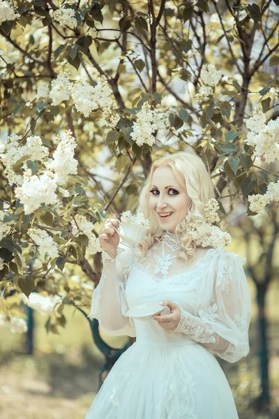 Mooie blonde vrouw tijdens de bloei Lila tuin. Vintage. Alice. — Stockfoto