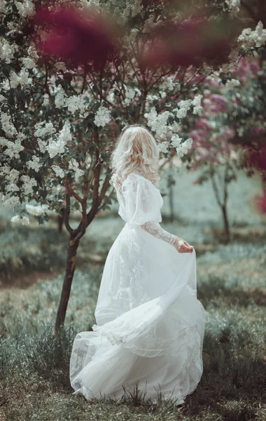 Zahrada krásná blondýnka v kvetoucí šeřík. Vintage nevěsta c — Stock fotografie