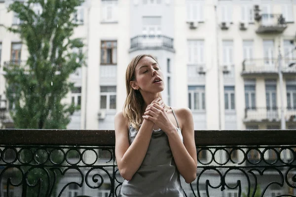 Mooi jong meisje in backless satijn jurk enjoyng de regen op — Stockfoto