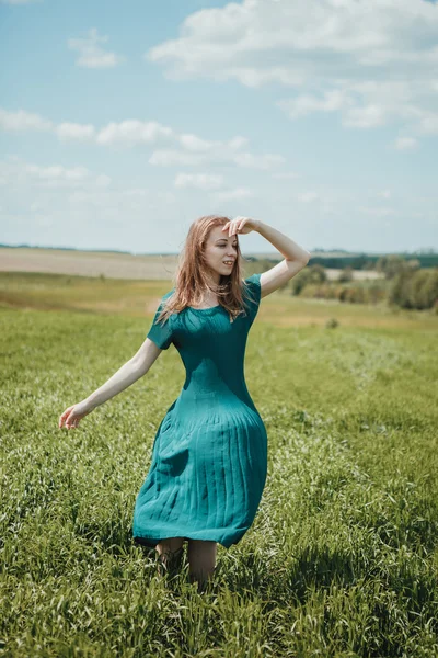 Menina bonita em vestido verde andando no campo de verão . — Fotografia de Stock